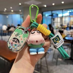 A hand holds a colorful keychain featuring a luna pro aido luolan q601 key shell case with a cartoon character design, a gree...