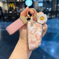 Elegant bmw 3 series key cover featuring a floral design with pink hues, complemented by a matching wrist strap and decorativ...