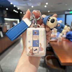 A hand holds a stylish car key cover featuring a dachshund design with playful icons, attached to a blue leather strap and a ...