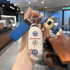 A hand holds a dachshund-themed key cover for li auto vehicles, featuring a blue strap and a cute dog charm, perfect for 2025...