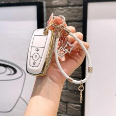 Elegant ford escape key cover with gold trim and a braided white wristlet, featuring a 3-button design and decorative charms ...