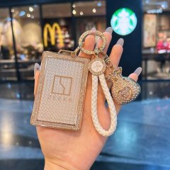 A hand holds a luxurious zeekr key card holder, featuring a slim leather design with a sparkling diamond-encrusted frame and ...