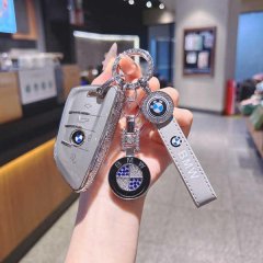 Elegant bmw x5 key cover featuring a slim blade design, adorned with sparkling embellishments and a matching leather strap, p...