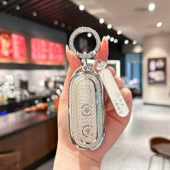 A hand holds a sparkling, silver key cover for the ideal l7/l8 pro/l9 max, featuring a diamond-like texture and a matching ke...