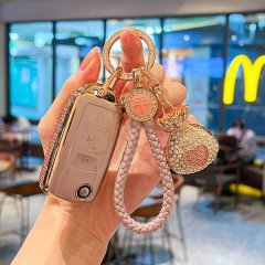 A hand holds a stylish vw key cover for passat, magotan & id.3, featuring premium leather with rhinestone accents and a decor...