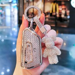 Elegant volkswagen viloran key cover (2022-2023) adorned with sparkling crystals, featuring a matching teddy bear charm and s...
