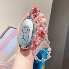 A hand holds a sleek, silver geely galaxy l7 key cover adorned with sparkling beads and a delicate butterfly charm, perfect f...