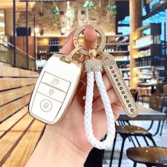 A hand holds a stylish kia k3 key cover featuring a slim silicone design with gold accents and a white braided lanyard, perfe...