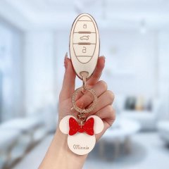 A hand holds a benteng t77 key cover, featuring a sleek white and gold design with a minnie mouse charm, showcasing its premi...