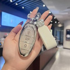 A hand holds a stylish b70 key cover for faw besturn models, featuring a sleek metallic design with sparkling embellishments ...
