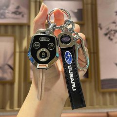 A hand holds a subaru key fob with a sleek rbz leather key cover, featuring the subaru logo and a carabiner for added functio...