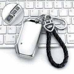 Elegant kia seltos key cover with sleek silver design and black leather strap, featuring a close-up of the remote buttons, pe...