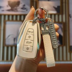 A hand holds a sleek, white gl auto key cover for geely emgrand s and xingyue l, featuring a diamond-embellished keychain and...