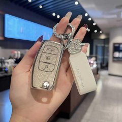 A hand holds a ford focus key cover with a glittery finish, featuring a diamond-encrusted keychain and a white leather tag la...