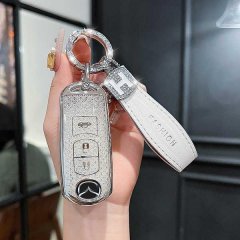 Elegant mazda key cover for cx-5, cx-30, cx-9 & mazda3, featuring a glittery finish and a stylish white leather strap with fa...