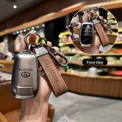 Hand holding a toyota key cover with wooden strap, showcasing front view of sleek design for camry, rav4, corolla, and more.
