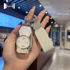 Hand holding a stylish leapmotor t03 key cover with a glittery design and leather tag, showcasing elegant protection for your...