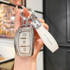 A hand holds a sleek, silver hyundai key cover with a h charm and a white leather strap labeled fashion, designed for models ...