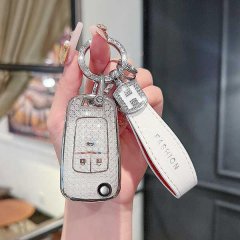 A hand holds a stylish chevrolet cruze key cover with a glittery finish, featuring a white leather strap labeled fashion and ...
