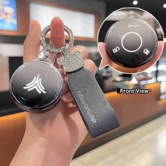 Hand holding neta v key cover pro, showcasing its sleek black design with a front view of the key fob and leather strap featu...