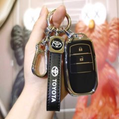 A hand holds a sleek toyota key cover designed for camry, highlander, and corolla hybrid models, featuring a black leather st...