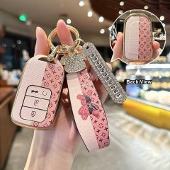 Elegant pink honda key cover with lv-inspired pattern, featuring a decorative strap and back view showcasing detailed design ...