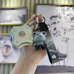 A hand holds a sleek suzuki jimny key cover with a metallic finish, accompanied by a cute bear keychain and a stylish leather...