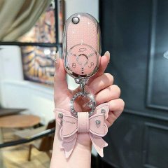 A hand holds a pink benteng xiaoma 2024 key cover featuring a cute horse design, adorned with a decorative bow and sparkling ...