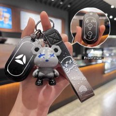 A hand holds a yadea m5/e8/q6 key cover, featuring a soft tpu protective sleeve with a cute bear charm and a front view inset...