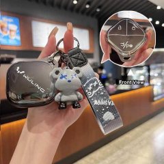 A hand holds a wuling binguo key cover featuring a cute bear charm and a cloud-style silicone design, with a close-up showing...