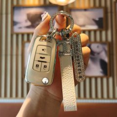 A hand holds a stylish buick key cover for excelle, verano, envision & gl8, featuring a sleek design with a leather strap and...