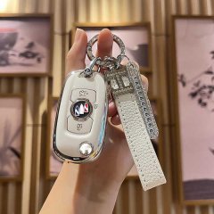 A hand holds a stylish white vinfast key cover for v3/v5/v7/v8, featuring a sleek design with a leather strap and decorative ...