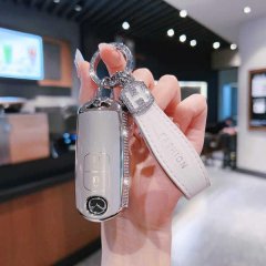 A hand holds a sleek, silver mazda key cover with a fashion leather strap, designed for mazda3 axela and cx-5 models, showcas...
