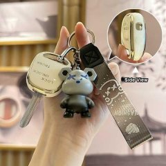 A hand holds a malaysia toyota flat key cover featuring a luxury leather sleeve with a cute bear charm. the key cover include...