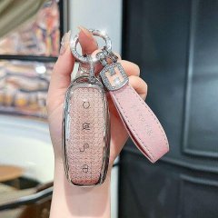 A hand holds a tengshi d9/n7/n8 key cover, featuring a glittery pink leather shell with a matching strap and a silver f logo ...
