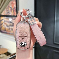 A hand holds a stylish pink perodua toyota key cover with glittery texture and leather strap, featuring a sleek design for re...
