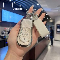 A hand holds a stylish, glittery key cover for the xpeng x9, labeled d model, featuring a sleek design with a matching leathe...