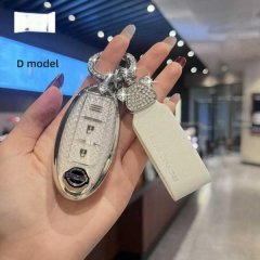 A hand holds a stylish nissan key cover for sylphy, x-trail, and teana, featuring a glittery design and a decorative charm, s...