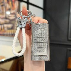 A hand holds a gac trumpchi m8 key cover, featuring a full-enclosure snap-on shell with a glittery texture and a decorative k...