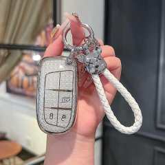 A hand holds a jeep leather key cover for compass, cherokee, and renegade, featuring a sleek design with a braided white stra...