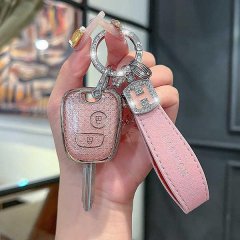 A hand holds a pink, glittery key cover for peugeot 207, 206, 307, and citroen c2, featuring a sleek design with a leather st...
