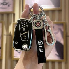 A hand holds a sleek fiat 500 key cover, featuring a black leather strap with the fiat logo and a metallic keychain, designed...
