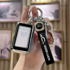 A hand holds a sleek starline a93 russian car key cover, featuring a metallic frame and a good luck strap with a car icon, se...