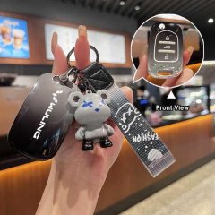 Hand holding a wuling hongguang s key cover with a stylish mini ev design, featuring a cute bear charm and a clear front view...