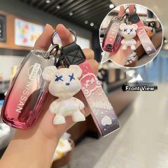 Hand holding a nissan altima 2023 key cover with a stylish white bear charm and patterned strap, showcasing a front view of t...