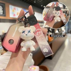A hand holds a volkswagen passat b9 key cover with a gradient pink design, featuring a cute bear charm and a matching wrist s...