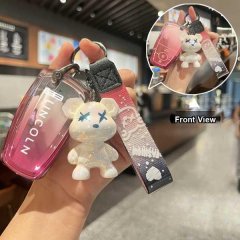 Hand holding a lincoln corsair key cover with a pink gradient design and a cute bear charm, showcasing both front and side vi...
