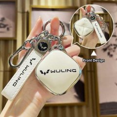 Hand holding a sleek wuling binguo key cover with a white leather strap and front design, showcasing its modern and protectiv...