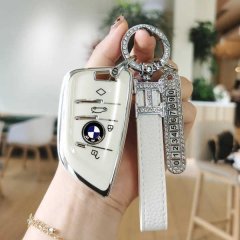 Elegant bmw key cover for 3/5/7 series and x1/x3/x5, featuring premium leather, a sleek design, and a decorative keychain wit...