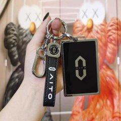 A hand holds a sleek aito wenjie m5 m7 card key cover, featuring a black leather strap with aito text and a metallic design, ...